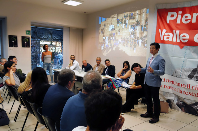 ピエモンテ州議会議長らが出席した会見で食と自然エネルギーの取り組みを話す安原潤神戸市食都神戸担当部長＝トリノ