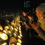 今年も一緒に。亡くなった弟を思い、蘇理剛志さん（右）は両親と並んで手を合わせた＝１７日午前６時１０分、神戸市中央区加納町６、東遊園地（撮影・田中靖浩）
