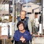 夫の雅男さんに押してもらいながら、車いすで近所を散歩する村田延子さん＝神戸市北区鹿の子台（撮影・風斗雅博）