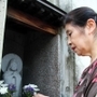 自宅玄関前に設けた「わらべ観音」を見詰める加賀翠さん。像に亡き長女の面影を重ねる＝神戸市東灘区森南町１