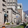 現在の京町筋。左の立体駐車場が鈴木商店の本店跡＝神戸市中央区海岸通（撮影・田中靖浩）